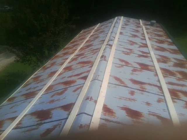 Rusted metal roof panels with new wood purlins before replacement — Storm Damage Roof Repair in Nellis Afb by Roofing Brothers