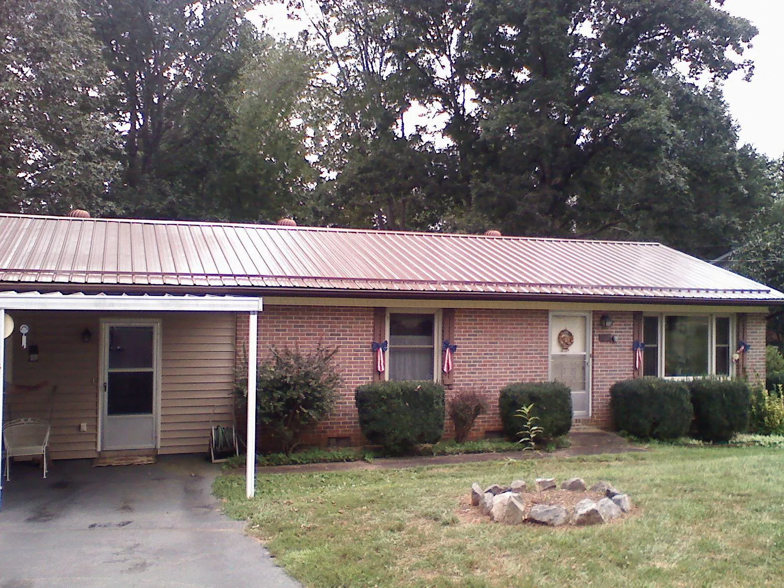 Bronze metal roof and carport on a brick ranch home — Roof Repair work by our crew in Nellis Afb